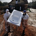 Devecser residents rescue usable items from their home flooded by toxic red sludge.
