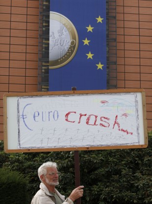 A man holds a sign outside the EU HQ in Brussels, where the two-day summit will take place
