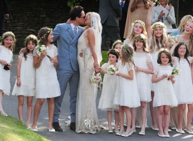 Kate Moss kisses her new husband Jamie Hince (left) after their wedding at St Peter's Church in Southrop.