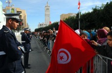 A woman holds a Tunisian flag as she celebrates the first anniversary of the revolution in Sidi Bouzid