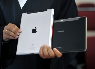 A file photo of a lawyer holding an Apple iPad and a Samsung Tablet-PC at a court in Dusseldorf, Germany.