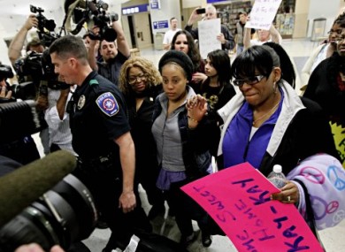Jakadrien Lorese Turner, centre, is surrounded by family and friends as she leaves Dallas-Fort Worth International Airport yesterday.