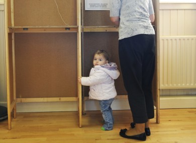 SÃofra Hughes, 1, waits as her mother Siobhán votes in October's presidential election.
