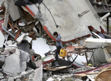 A Palestinian boy walks through the rubble of a destroyed building following an Israeli air strike in Jabaliya on Monday