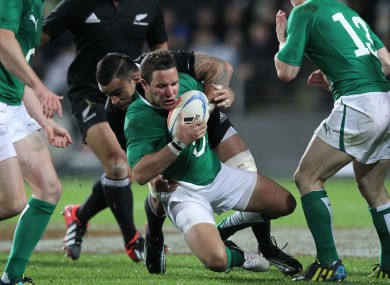 Paddy Wallace is thundered back in the tackle.