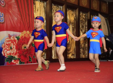 Chinese children wearing bathing suit walk on runway during a celebration for Children's Day
