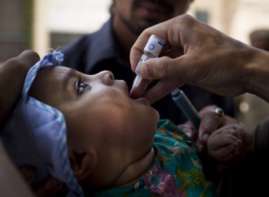 A Pakistani child is given a polio vaccination by a health worker