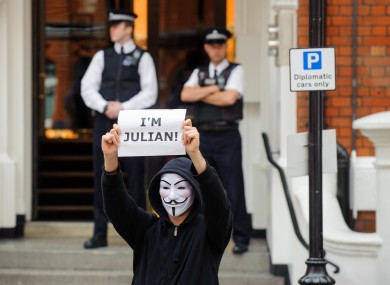 A masked supporter of Julian Assange outside the Embassy of Ecuador in London this afternoon