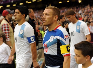 Great Britain captain Craig Bellamy (right) and Uruguay's Luis Suarez walk out prior to the group A match against Uruguay at the Millennium Stadium last night.