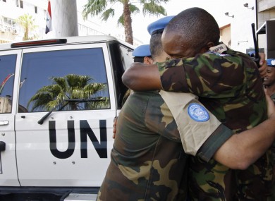 United Nations observers embrace upon arrival in Damascus, Syria from Homs, as they prepare to depart the country today