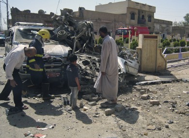 Citizens and security forces inspect the scene of a car bomb attack in Kirkuk, 290 kilometers (180 miles) north of Baghdad, Iraq