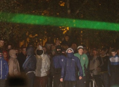 Masked people gathering at the scene of disorder on Sunday night