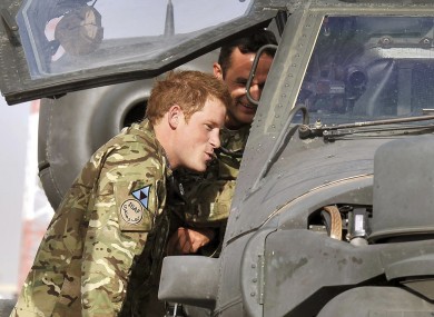 File photo of Prince Harry examining an Apache helicopter with a member of his squadron at Camp Bastion