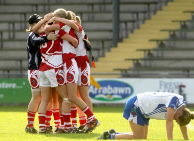Cork players celebrate the final whistle as Ellen McCarron of Monaghan drops to the ground.