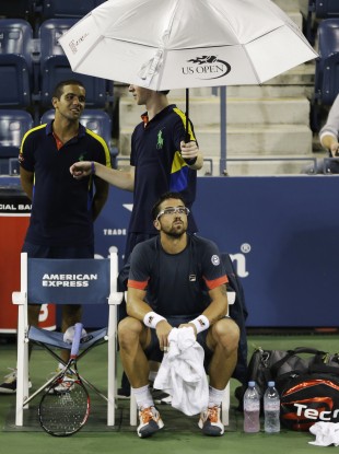 Janko Tipsarevic waits as play is suspended in his match with Philipp Kohlschreiber.