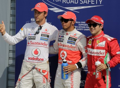 McLaren Mercedes driver Lewis Hamilton, centre, of Britain, smiles after clocking the fastest time flanked by McLaren Mercedes driver Jenson Button, left, of Britain, who set the second fastest time, and Ferrari driver Felipe Massa, of Brazil, third fastest time.