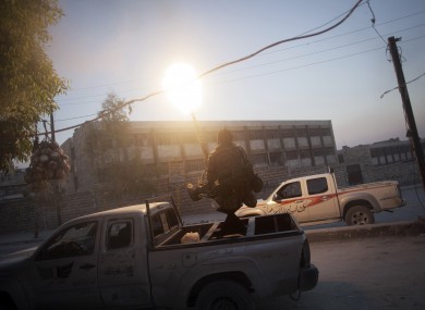 A fighter from the Free Syrian Army fures an anti-aircraft machine gun into the air in Aleppo yesterday