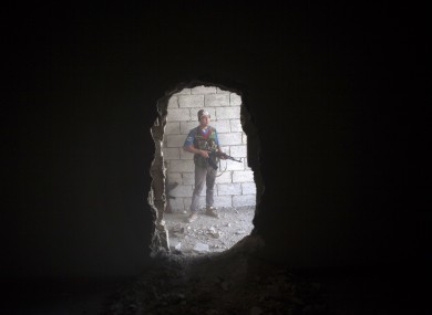 Free Syrian Army fighter takes cover in a building during clashes against the Syrian Army in Aleppo today.