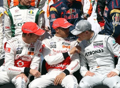 Lewis Hamilton and Jenson Button chatting with Michael Schumacher during the annual drivers team photo prior to the Gulf Air Bahrain Grand Prix at the Bahrain International Circuit yesterday.