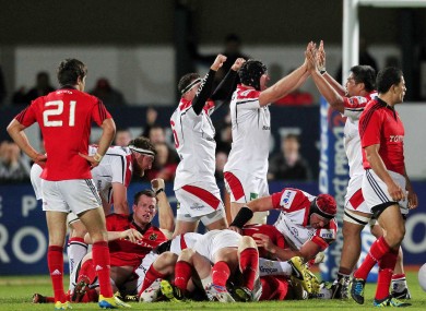 Conor Murray (Munster) reflects on his side's defeat as Stephen Ferris (Ulster) celebrates.