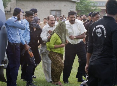 The young girl is escorted by police official to a helicopter following her release.