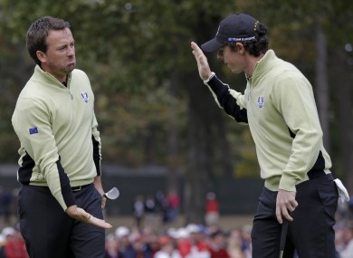 Europe's Graeme McDowell, left, is congratulated by Rory McIlroy after making a putt to half the 13th.