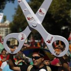 A man holds scissors in protest against austerity measures at Columbus Square in Madrid. (AP Photo/Andres Kudacki)