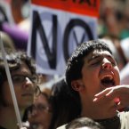 People shout slogans and show a banner reading