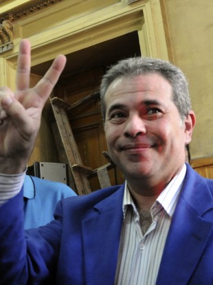 Tawfiq Okasha flashes the victory sign as he arrives in court in Cairo yesterday.