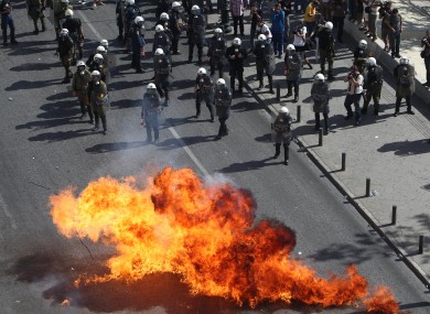 Protesters throw petrol bombs against riot police during a 24-hour nationwide general strike in Athens.