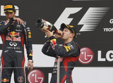 Red Bull driver Sebastian Vettel of Germany, centre, drinks champagne as he celebrates with teammate and second placed Mark Webber.