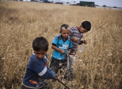 Syrian boys play near a refugee camp on the border with Turkey