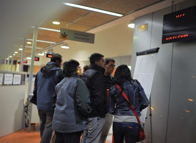 People are seen through the window, as they look at the list of jobs in an employment office, in Pamplona, northern Spain
