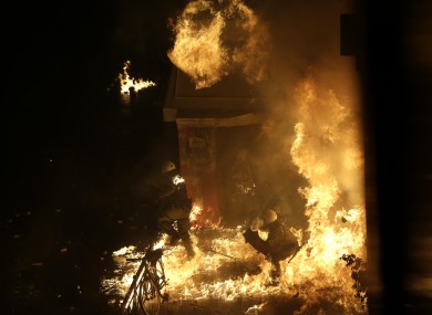 A petrol bomb thrown by protesters explodes near riot police in front of parliament during clashes in Athens, Wednesday Nov. 7, 2012.