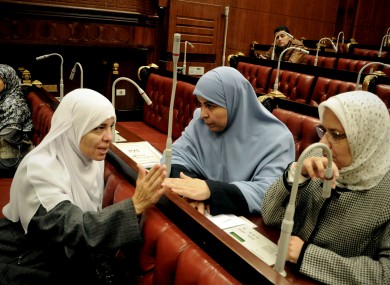 Azza el-Gharf of the Muslim Brotherhood's Freedom and Justice Party, second left, speaks with other members of the assembly during the vote last night