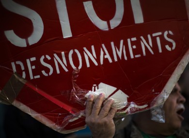 A demonstrator holds a banner calling to