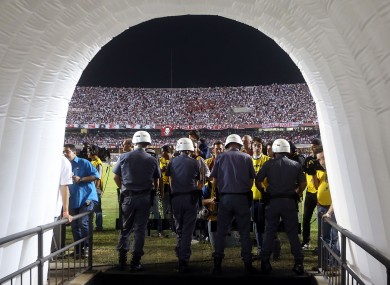 Police officers stand guard the entrance to Argentina's Tigre's dressing room after a fight among teams' members at the end of the first half.