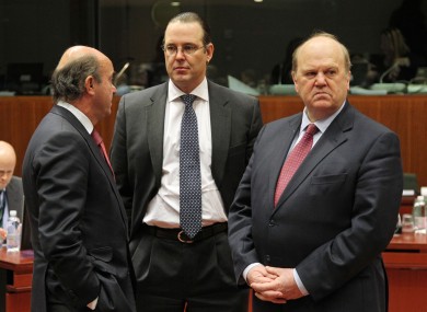 Michael Noonan looks on, as Spanish Economy Minister Luis de Guindos Jurado, left, and Swedish Finance Minister Anders Borg talk to each other, during the EU finance ministers meeting.