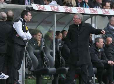 Manchester United manager Sir Alex Ferguson (right) speaks with fourth official Lee Probert (left) on the touchline.