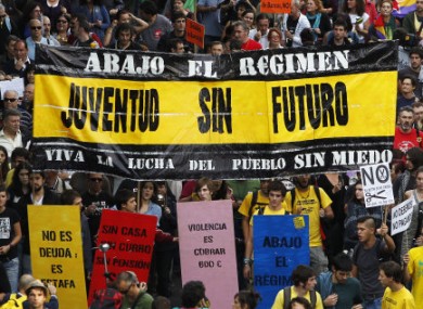 Protesters march in Madrid and hold banners reading, 'A youth with no future'.