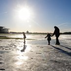 People walk on the remaining frozen flood water on York Racecourse (Anna Gowthorpe/PA Wire)