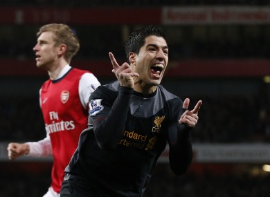 Liverpool's Luis Suarez, right, celebrates his goal as Arsenal's Per Mertesacker stands in the background during the Premier League match between Arsenal and Liverpool.